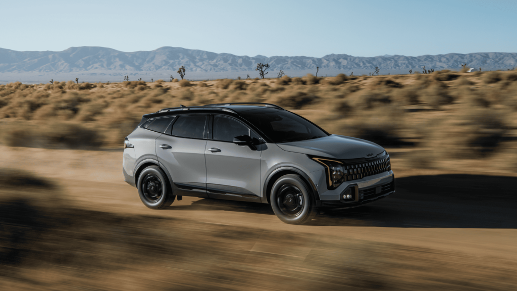 2026 Kia Sportage on a dessert road cruising fast.