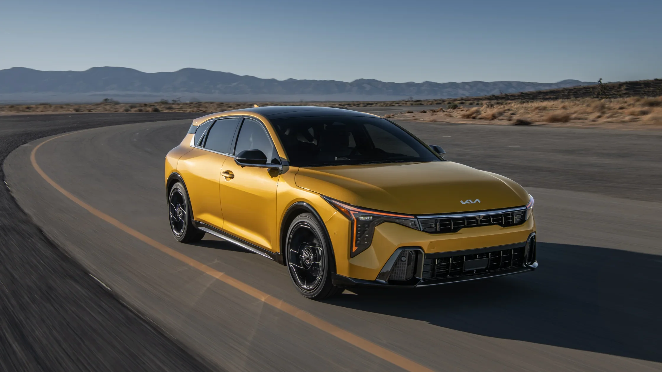 2026 Kia K4 Hatchback exterior driving on open road showing sporty hatchback design.