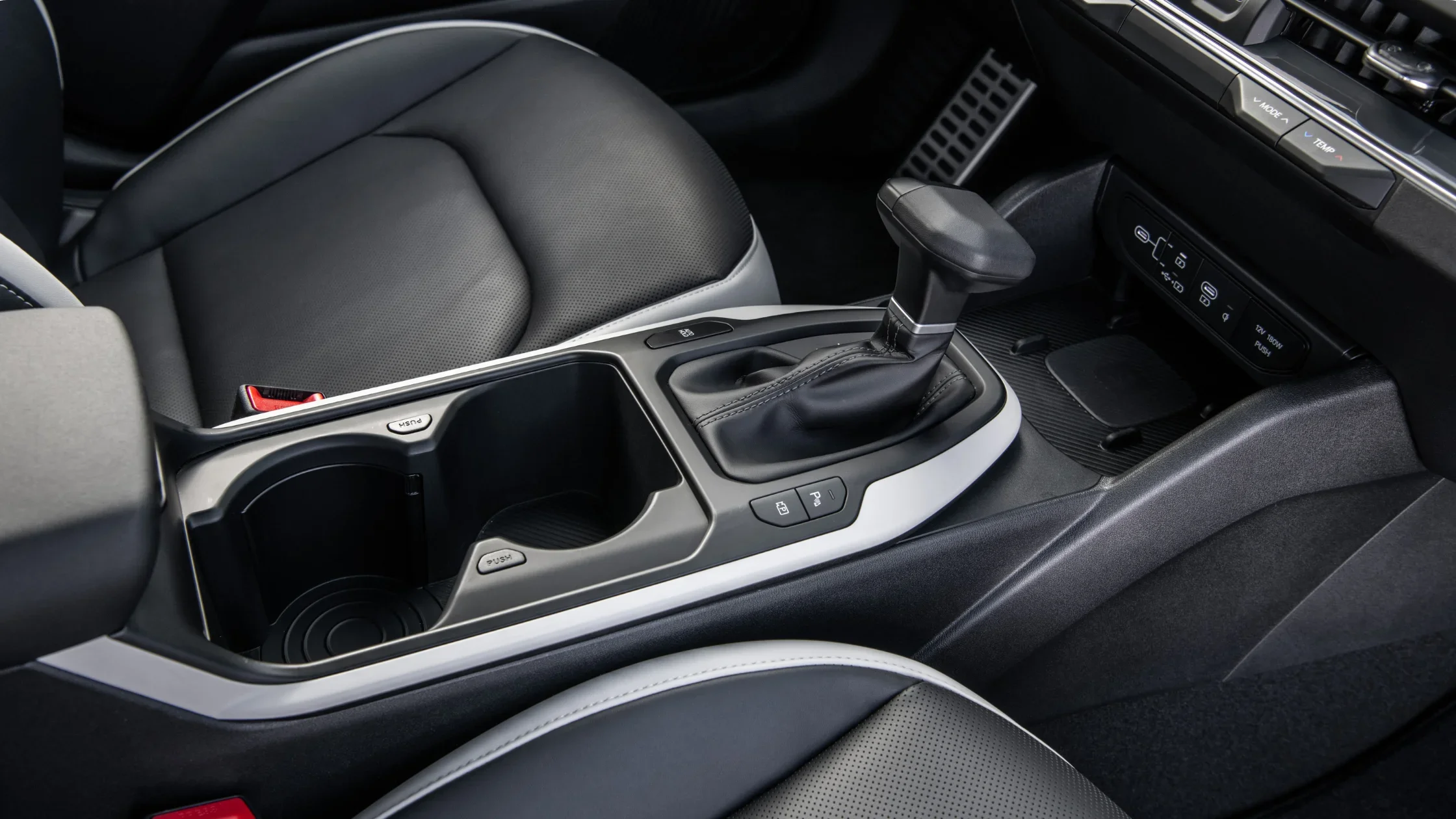 2026 Kia K4 Hatchback center console with automatic shifter, cupholders, and clean interior layout.