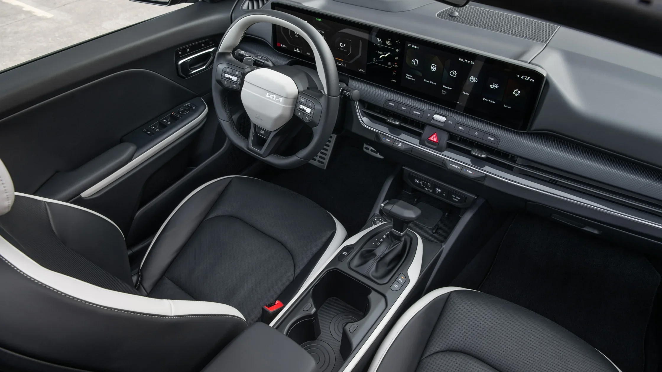 2025 Kia K4 front interior view with dual panoramic displays and black-and-white sport seating.