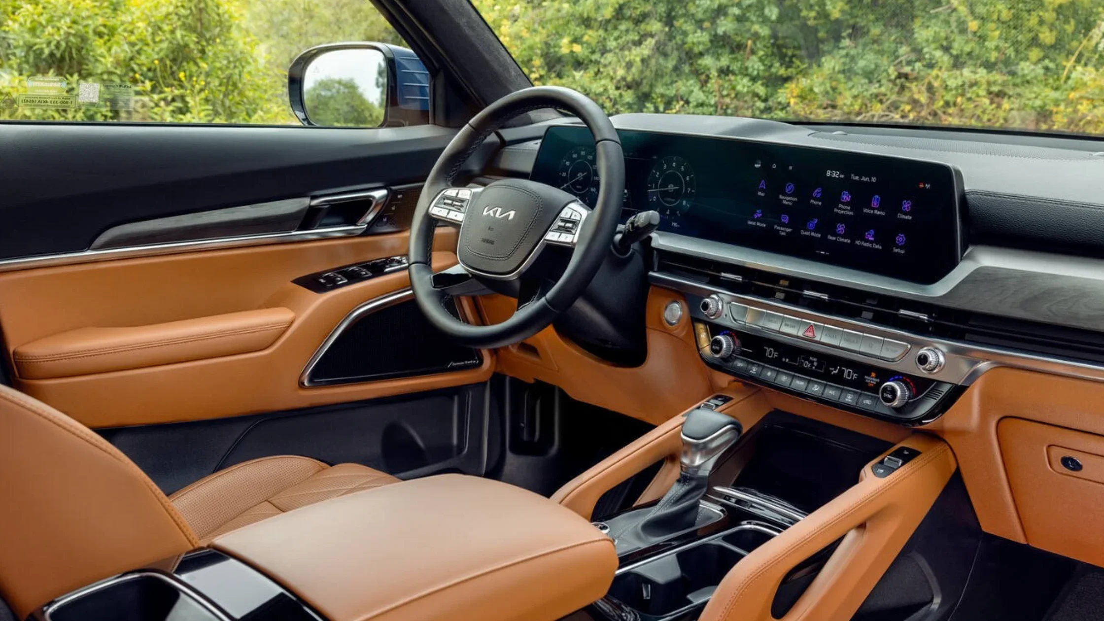 Interior view of the 2025 Kia Telluride front cabin with brown leather upholstery, digital dashboard, and infotainment display.