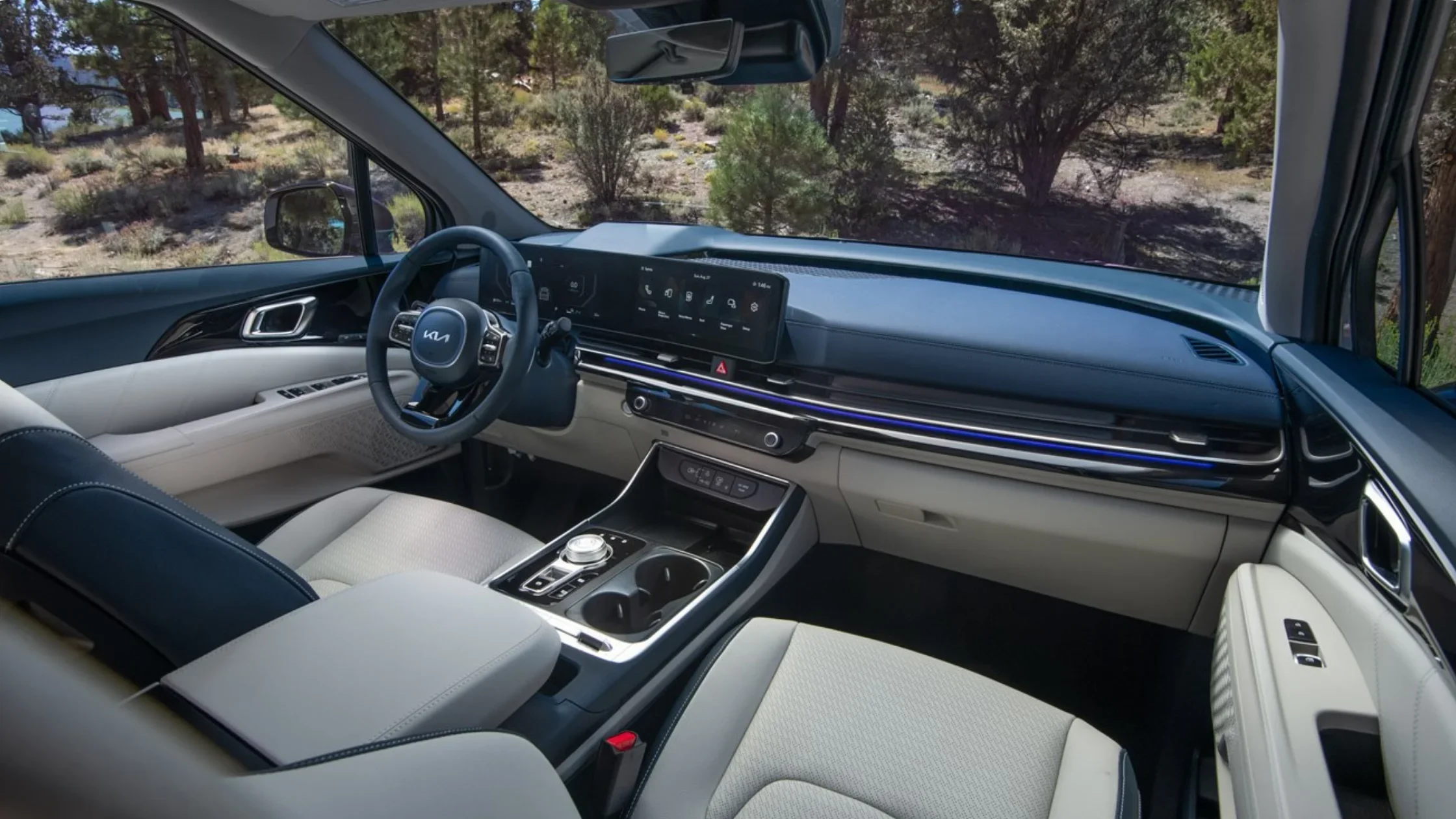 Front interior of the 2026 Kia Carnival HEV highlighting the dashboard and infotainment system.