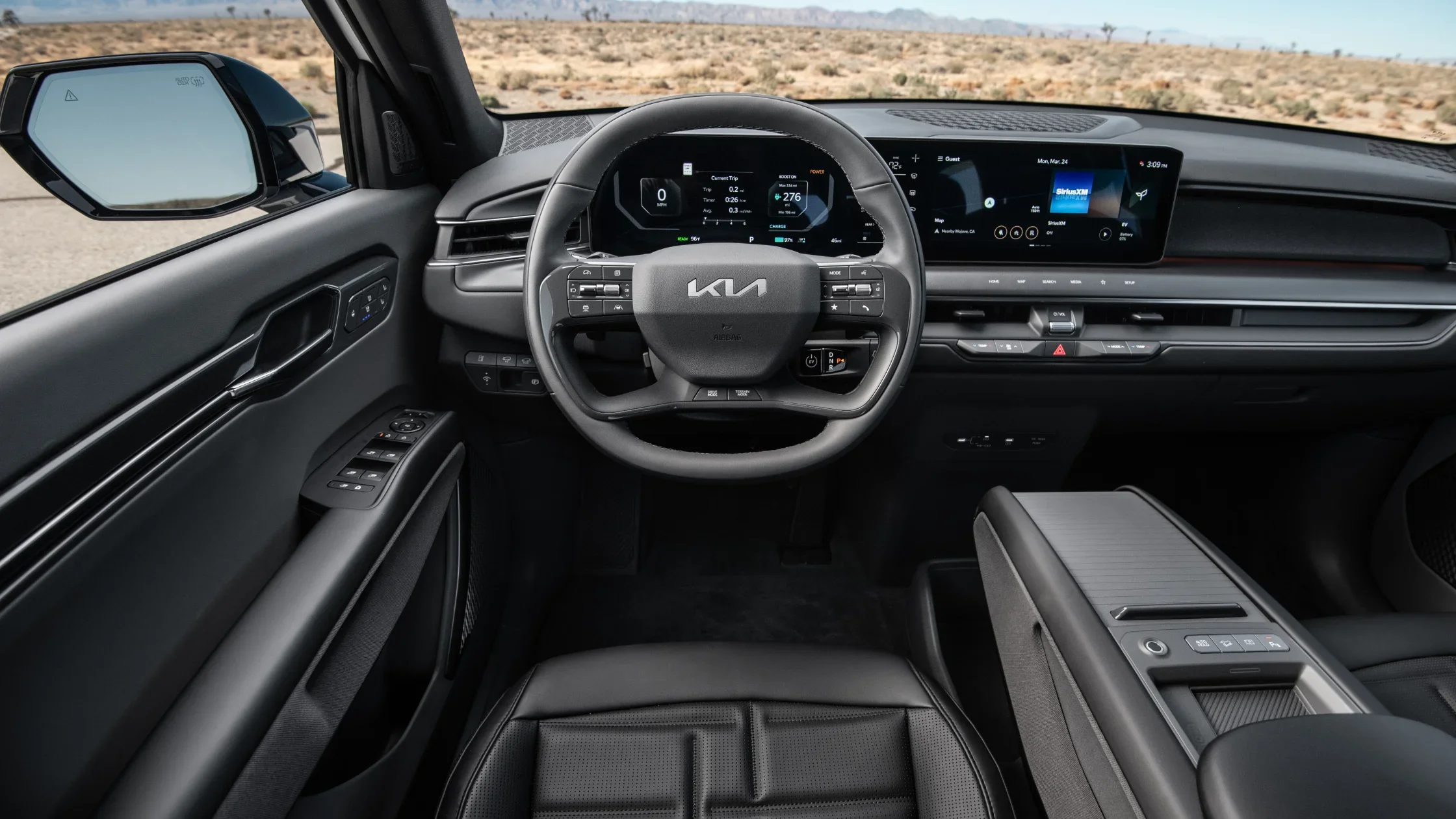 2026 Kia EV9 interior cockpit with digital driver display, steering wheel, and infotainment screen.