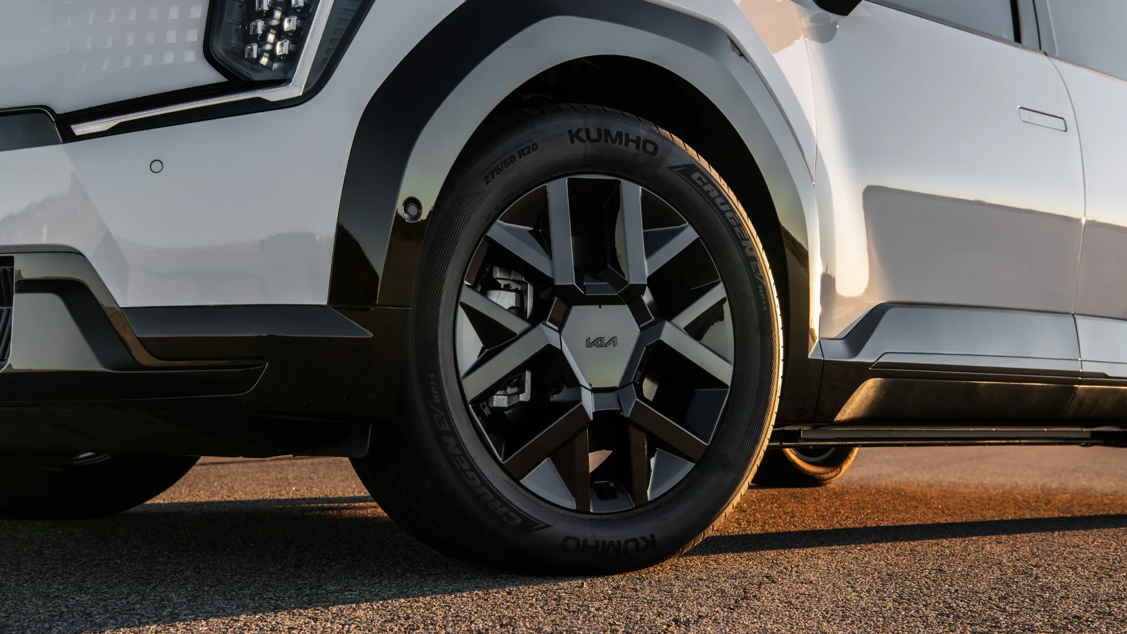 Close-up of 2026 Kia EV9 black alloy wheel with Kumho tire, sharp fender design, and LED accents.