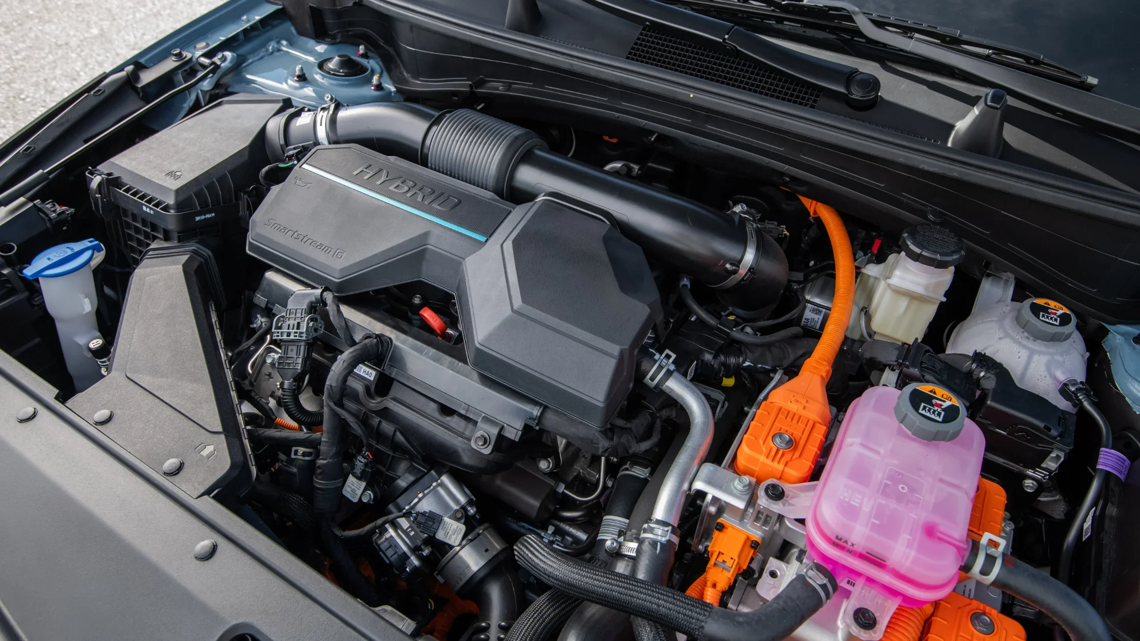 2026 Kia Sportage HEV hybrid engine bay with Smartstream G components and orange wiring detail.